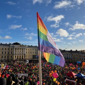 Sateenkaarilippu liehuu ammattiliittojen järjestämässä STOP Nyt -tapahtumassa Helsingin Senaatintorilla helmikuussa 2024