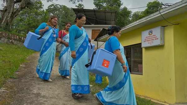 Neljä nepalilaista yhteisöterveydenhoitajaa menossa sisään kotikylänsä terveysasemalle